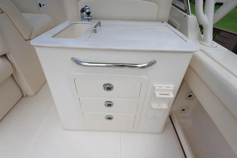 Slide: The Image of 2018 Grady-White Freedom 285 boat interior with sink and storage drawers. - 12