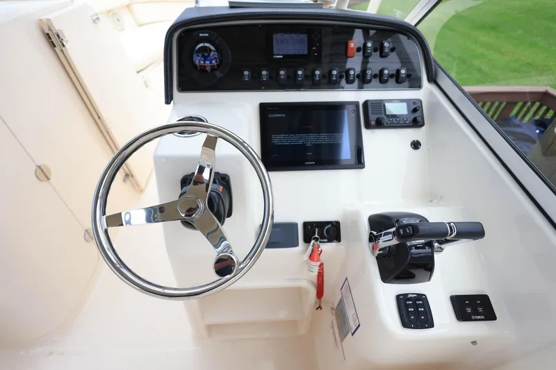 Slide: The Image of 2018 Grady-White Freedom 285 boat dashboard with steering wheel and control panel. - 19