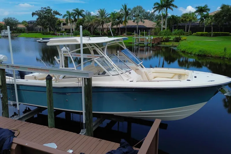 Slide: The Image of 2018 Grady-White Freedom 285 boat docked on a serene waterfront with lush greenery. - 4