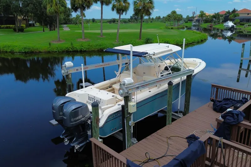 Slide: The Image of 2018 Grady-White Freedom 285 boat docked on a serene canal with lush greenery. - 5