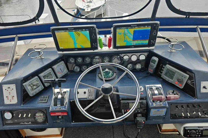 Slide: The Image of Cockpit of 1990 Sea Ray 440 Aft Cabin with navigation equipment and steering wheel. - 13