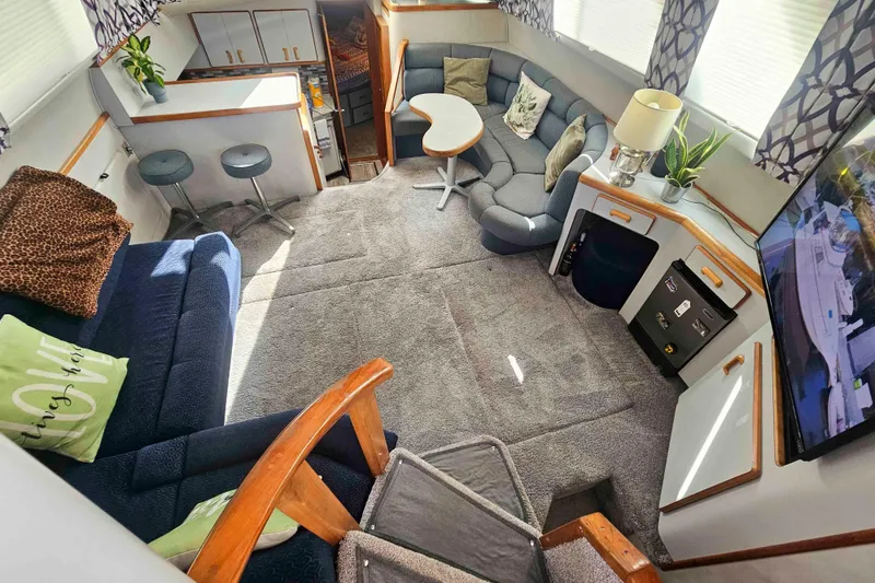 Slide: The Image of 1990 Sea Ray 440 Aft Cabin interior with cozy seating, modern decor, and natural light. - 14