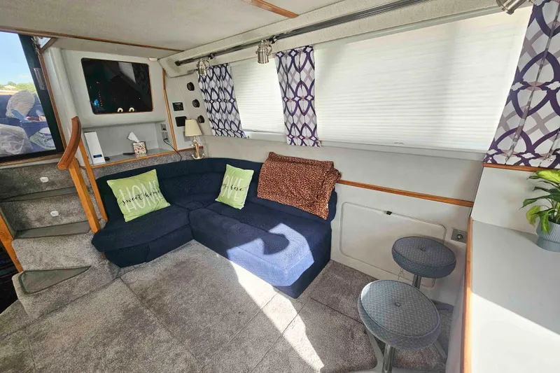 Slide: The Image of 1990 Sea Ray 440 Aft Cabin interior with cozy seating, decorative pillows, and modern decor. - 15