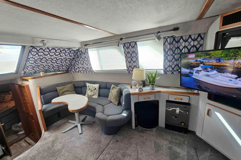 Slide: The Image of Cozy interior of 1990 Sea Ray 440 Aft Cabin with seating, table, and TV. - 18