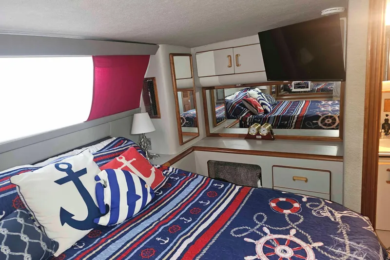 Slide: The Image of Nautical-themed bedroom in 1990 Sea Ray 440 Aft Cabin with anchor pillows and striped bedding. - 24