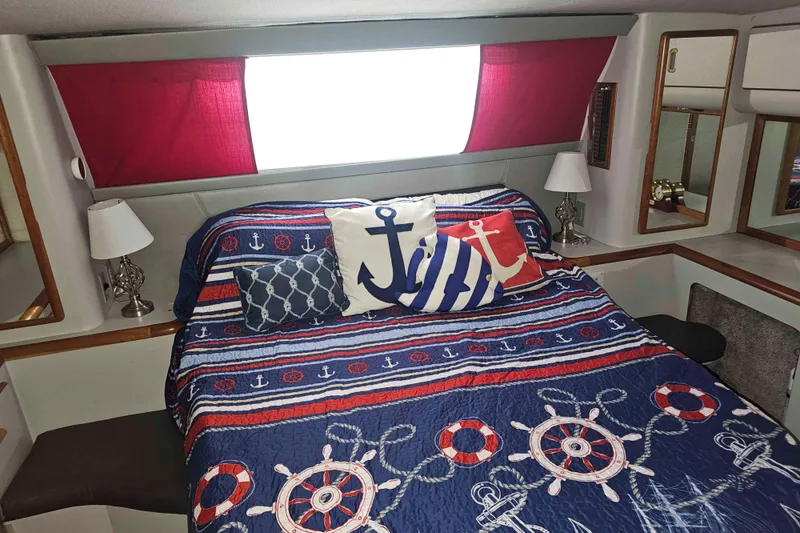 Slide: The Image of Nautical-themed bedroom in 1990 Sea Ray 440 Aft Cabin with anchor-patterned bedding. - 25