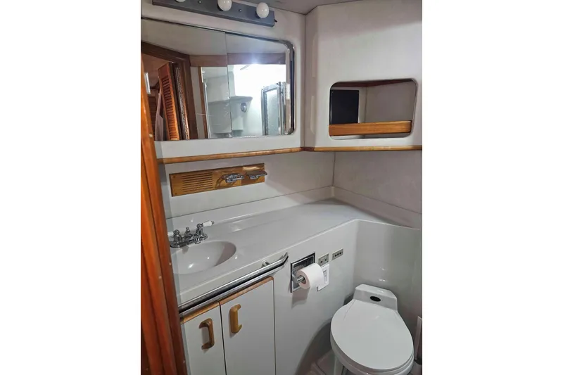 Slide: The Image of Bathroom interior of 1990 Sea Ray 440 Aft Cabin yacht, featuring sink and toilet. - 26