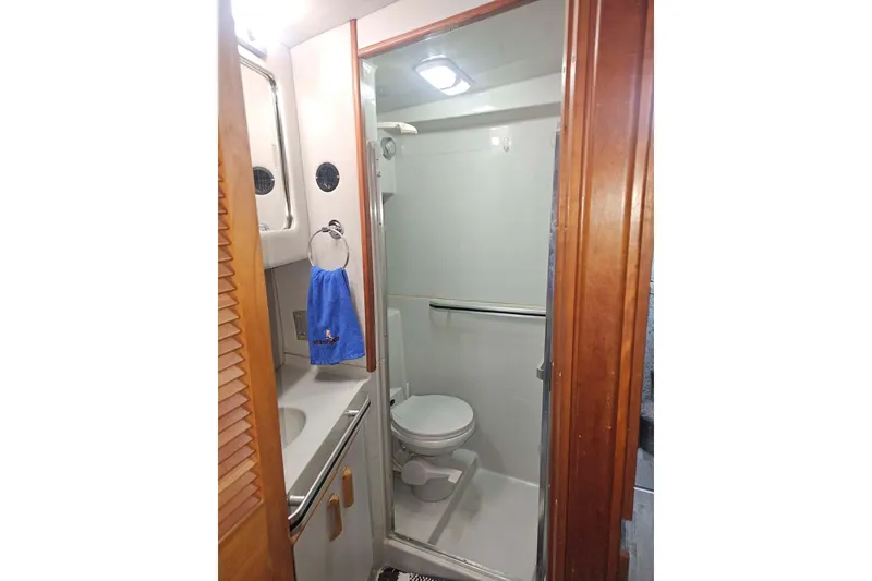 Slide: The Image of Bathroom interior of 1990 Sea Ray 440 Aft Cabin yacht, featuring shower and toilet. - 28