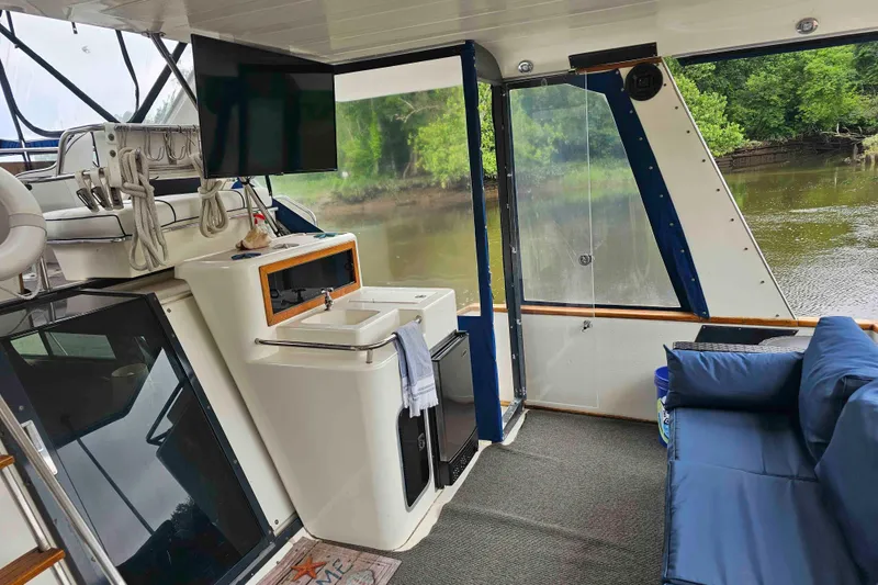 Slide: The Image of 1990 Sea Ray 440 Aft Cabin interior with sink, TV, and river view. - 5