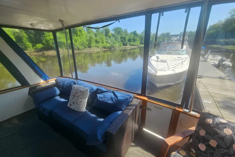 Slide: The Image of Interior view of 1990 Sea Ray 440 Aft Cabin with cozy seating and scenic waterway. - 6