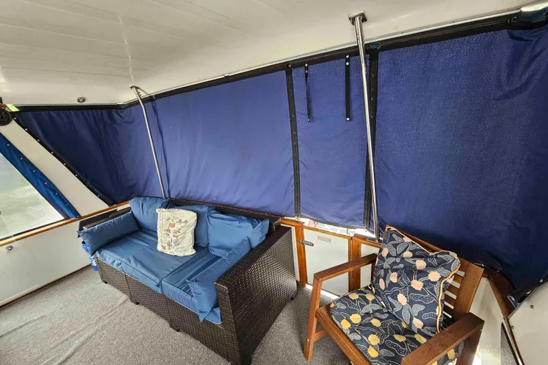 Slide: The Image of 1990 Sea Ray 440 Aft Cabin interior with blue seating and decorative cushions. - 9