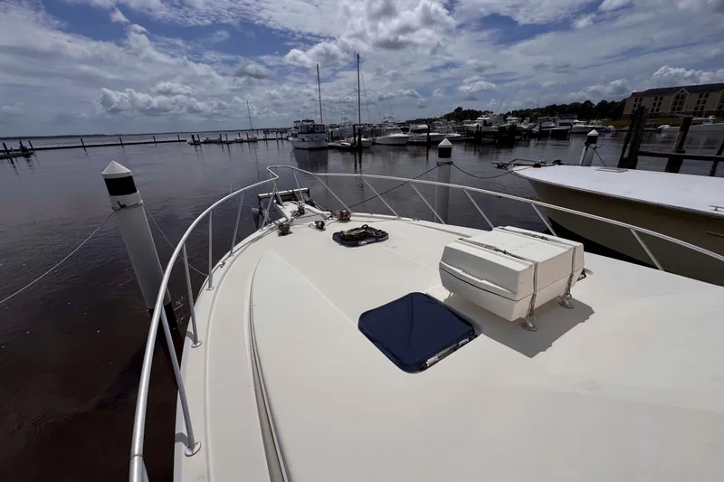 Slide: The Image of 1987 Chris-Craft 422 Commander yacht docked at a marina under a cloudy sky. - 16