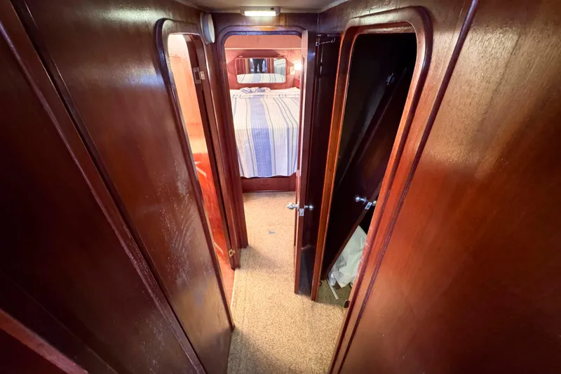 Slide: The Image of Interior hallway of 1987 Chris-Craft 422 Commander with wooden doors and carpet flooring. - 24