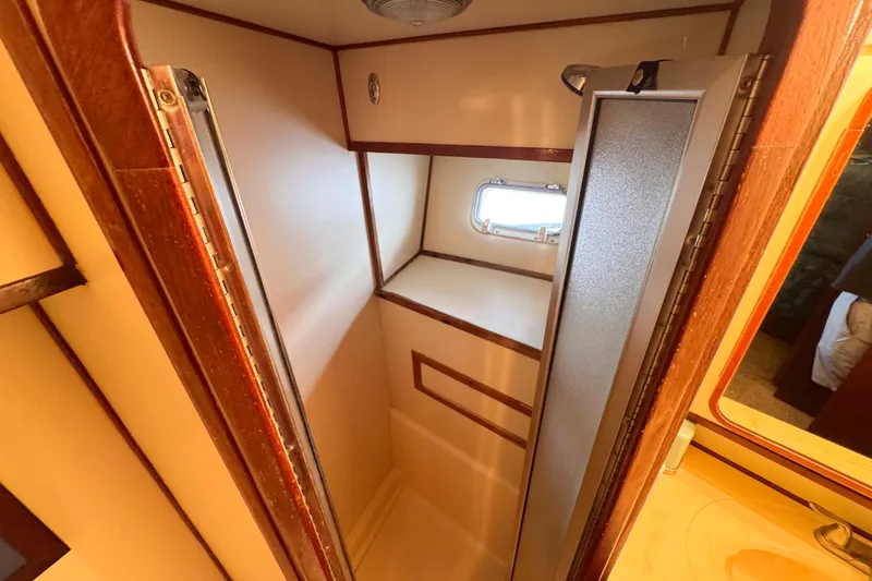 Slide: The Image of Shower area inside 1987 Chris-Craft 422 Commander yacht, featuring wood accents and a small window. - 28