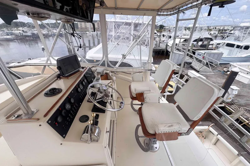 Slide: The Image of 1987 Chris-Craft 422 Commander helm with dual seats, docked at marina. - 3