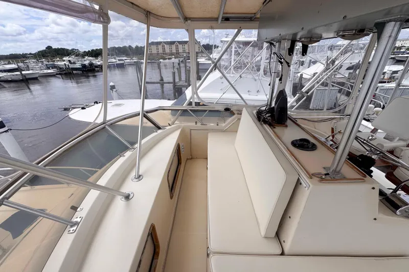 Slide: The Image of 1987 Chris-Craft 422 Commander boat interior at marina, featuring seating and navigation equipment. - 6