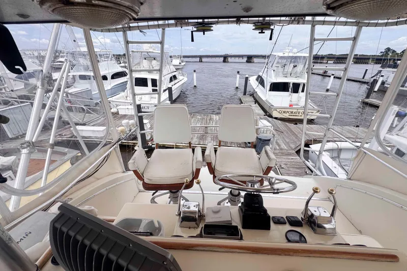 Slide: The Image of 1987 Chris-Craft 422 Commander helm view at marina, showcasing steering and controls. - 7