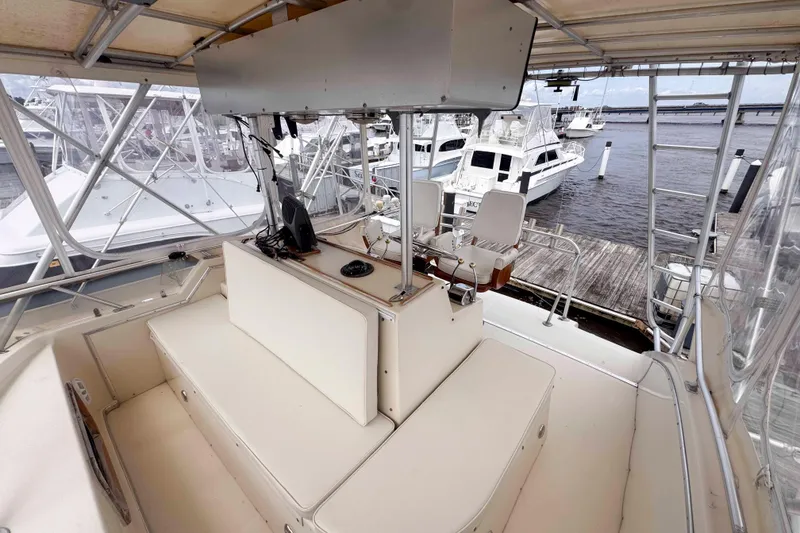 Slide: The Image of 1987 Chris-Craft 422 Commander yacht interior with helm and seating, docked at marina. - 8