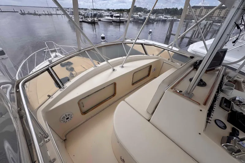 Slide: The Image of 1987 Chris-Craft 422 Commander yacht cockpit with marina view, showcasing helm and seating area. - 9