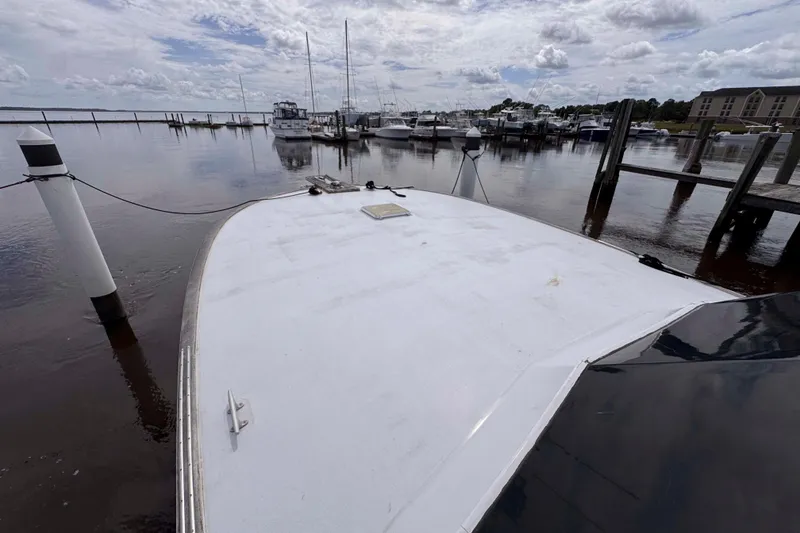 Slide: The Image of Bow view of 1989 Buddy Davis 47 yacht docked at a marina under cloudy skies. - 11