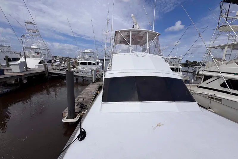 Slide: The Image of 1989 Buddy Davis 47 yacht docked at marina under blue sky. - 13