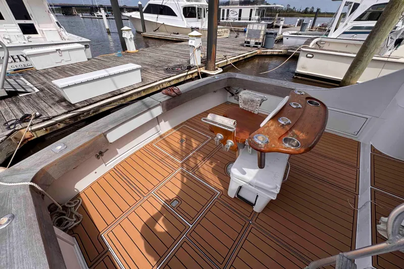Slide: The Image of Cockpit of 1989 Buddy Davis 47 yacht with wooden deck and fishing chair at marina. - 14