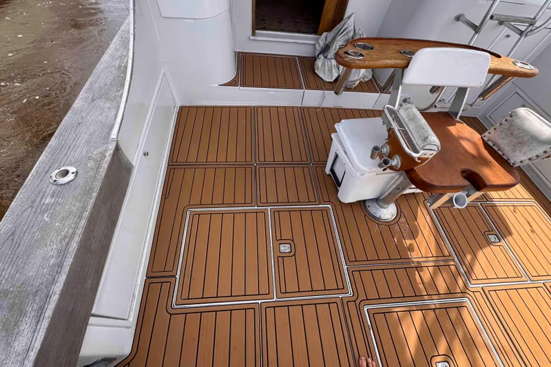 Slide: The Image of Fishing deck of 1989 Buddy Davis 47 boat with teak flooring and chair. - 17