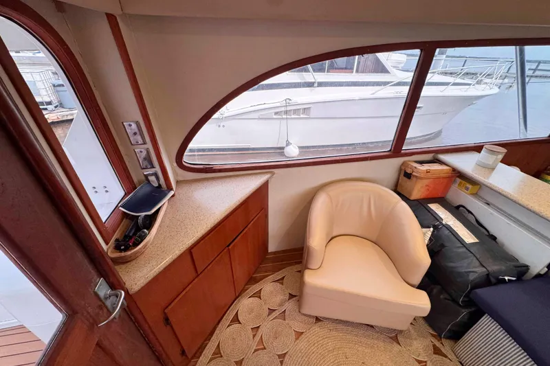 Slide: The Image of Interior of 1989 Buddy Davis 47 yacht with chair and window view of docked boat. - 22