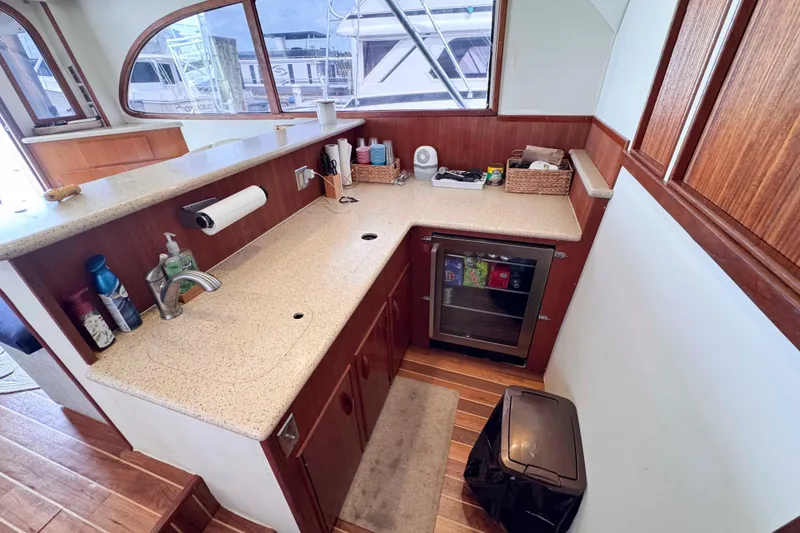Slide: The Image of Galley kitchen in 1989 Buddy Davis 47 yacht with wood cabinetry and mini fridge. - 23