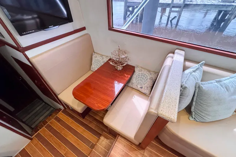 Slide: The Image of Cozy dining area in 1989 Buddy Davis 47 yacht with elegant wood table and plush seating. - 25