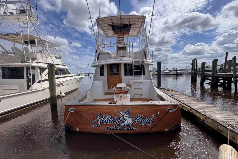 Slide: The Image of 1989 Buddy Davis 47 yacht docked, named "State of Mind," under a partly cloudy sky. - 5