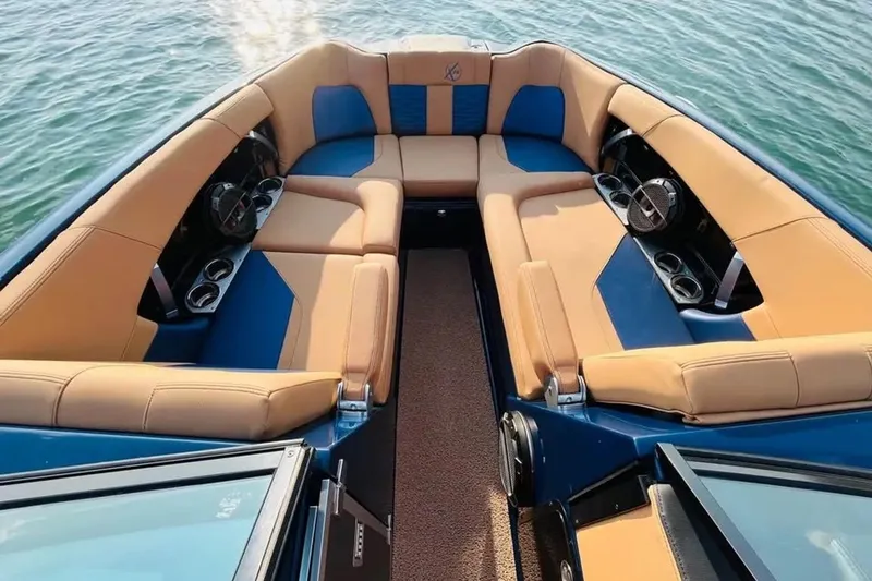 Slide: The Image of Luxurious 2019 MasterCraft X26 boat interior with tan and blue seating on water. - 6