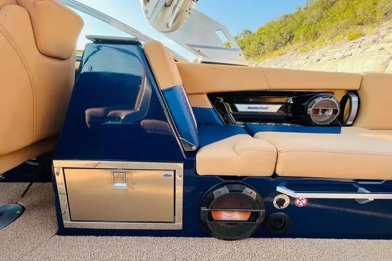 Slide: The Image of 2019 MasterCraft X26 interior with tan seating, blue accents, and premium audio system. - 9