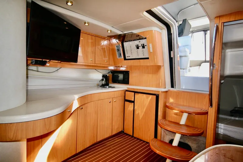 Slide: The Image of Interior of 2000 Regal Commodore 4160 yacht with modern kitchen and wooden cabinetry. - 14
