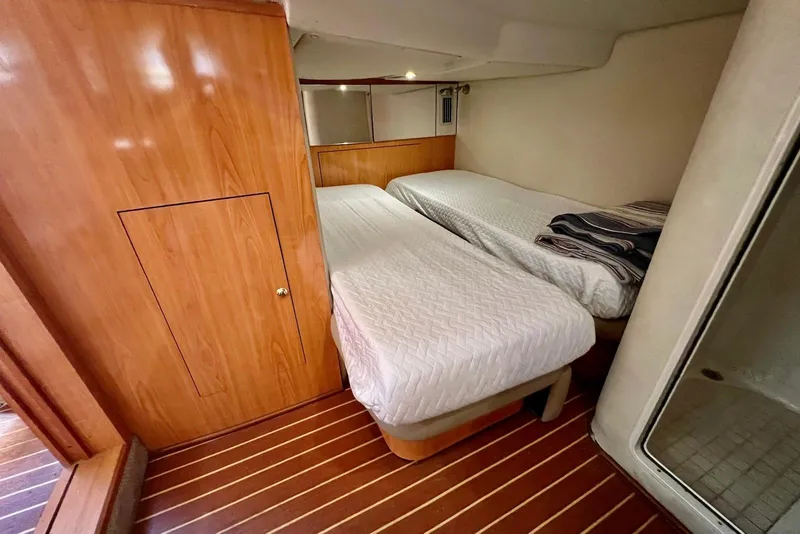 Slide: The Image of Twin beds in a 2000 Regal Commodore 4160 yacht cabin with wooden flooring. - 18