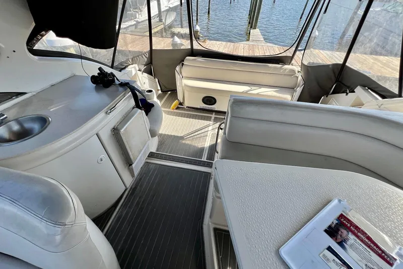 Slide: The Image of Interior of 2000 Regal Commodore 4160 yacht with seating, kitchenette, and water view. - 9