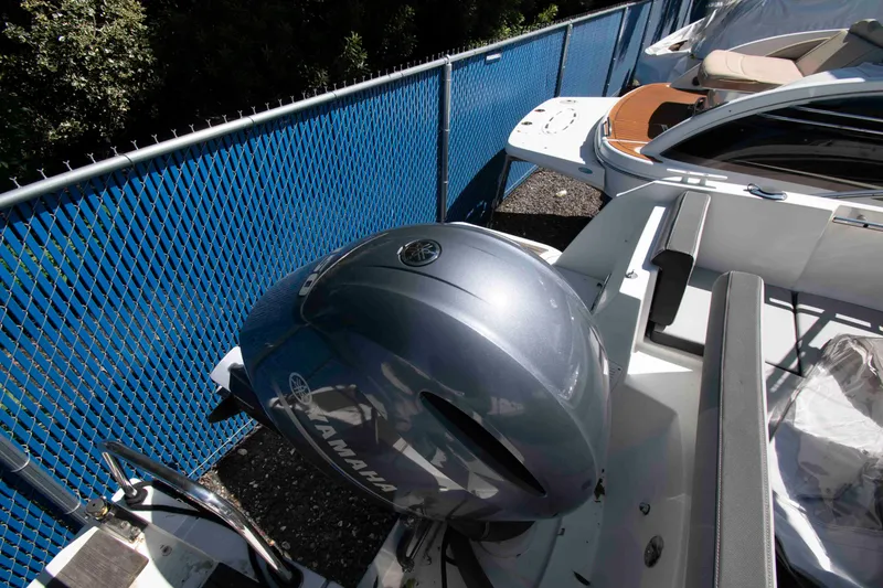 Slide: The Image of 2020 Jeanneau NC 695 boat with Yamaha outboard motor, parked near blue fence. - 12