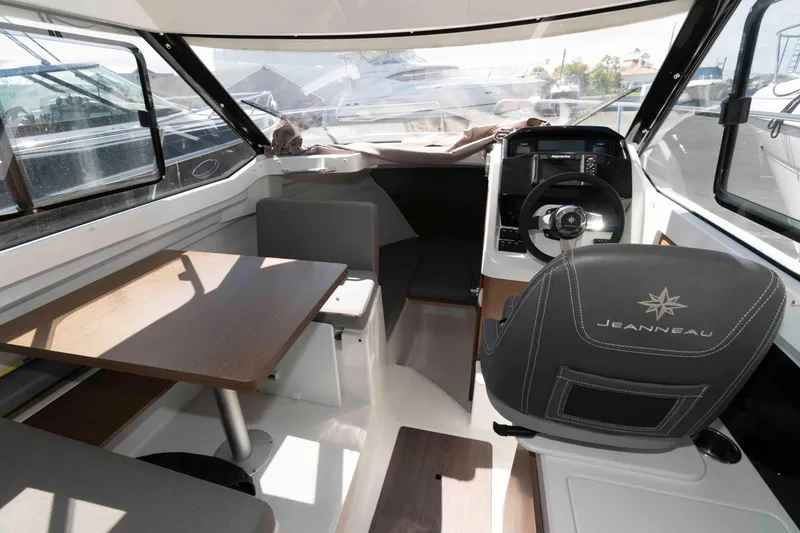 Slide: The Image of Interior of 2020 Jeanneau NC 695 boat with steering wheel and seating area. - 2
