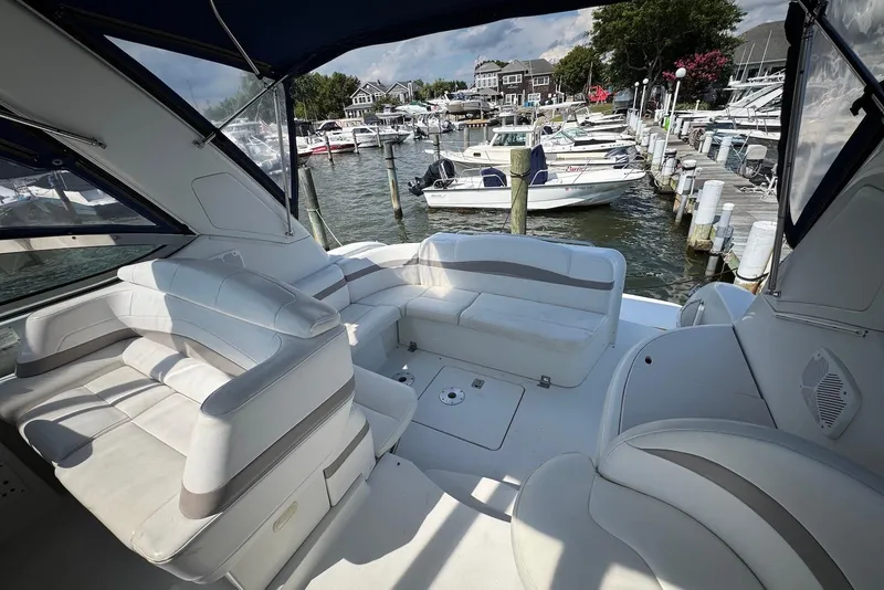 Slide: The Image of 2002 Formula 37 Performance Cruiser interior with marina view, featuring white seating and docked boats. - 10