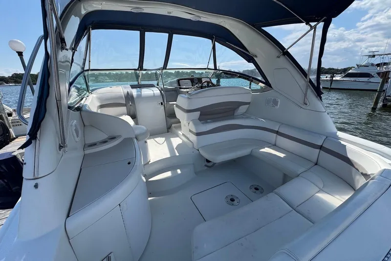 Slide: The Image of 2002 Formula 37 Performance Cruiser interior with white seating and helm, docked by the water. - 3