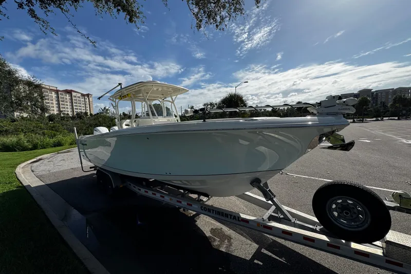 Slide: The Image of 2015 Sailfish 320 CC boat on trailer in parking lot under blue sky. - 11
