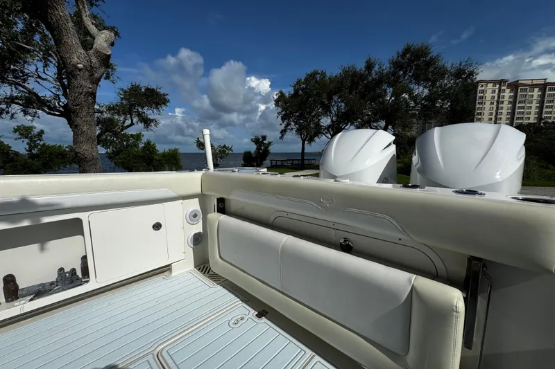Slide: The Image of 2015 Sailfish 320 CC boat interior with twin engines, scenic waterfront view. - 14