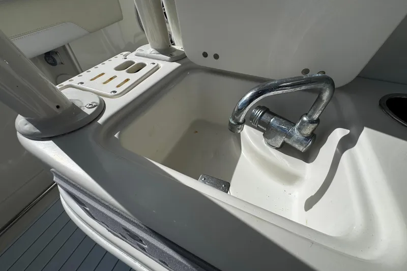 Slide: The Image of 2015 Sailfish 320 CC boat sink with faucet and rod holders. - 21