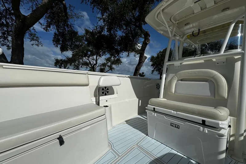 Slide: The Image of 2015 Sailfish 320 CC boat interior with seating and Yeti cooler under blue sky. - 22