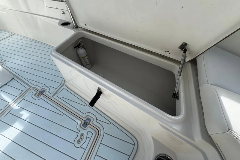 Slide: The Image of Open storage compartment on 2015 Sailfish 320 CC boat with fire extinguisher inside. - 23