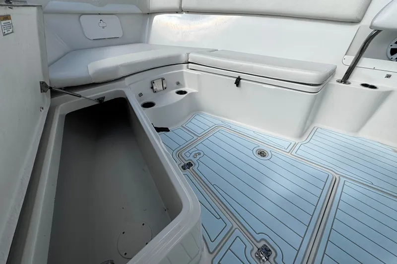 Slide: The Image of 2015 Sailfish 320 CC boat interior with seating and storage compartments. - 24