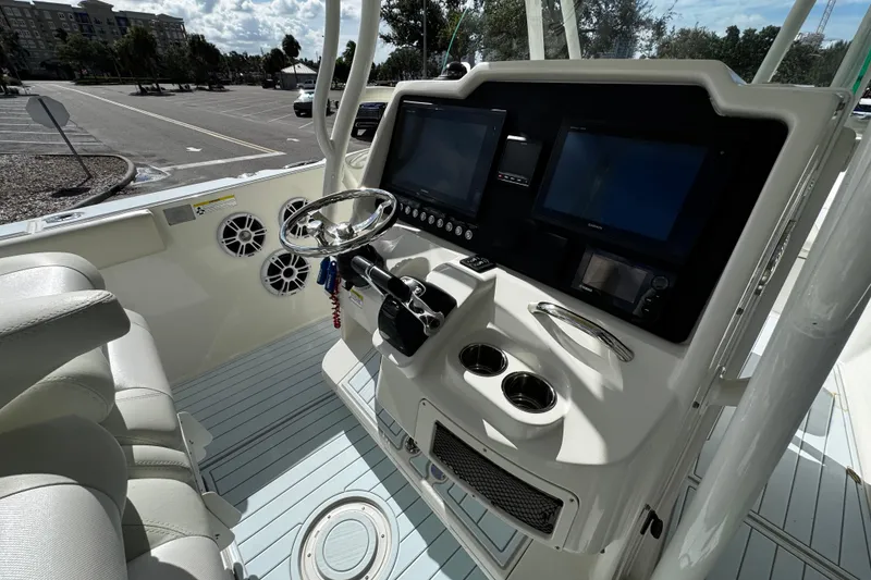 Slide: The Image of 2015 Sailfish 320 CC boat cockpit with dual screens and steering wheel. - 28