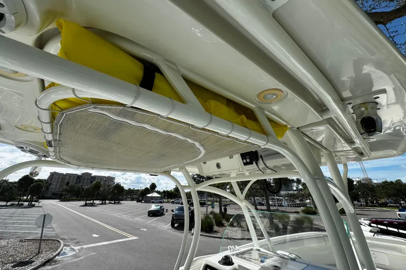 Slide: The Image of 2015 Sailfish 320 CC boat with overhead storage and yellow life jackets, parked in a lot. - 30