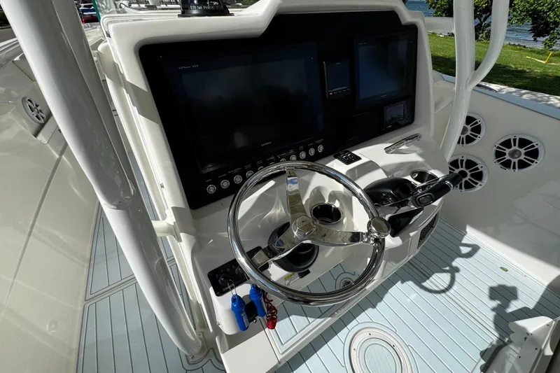 Slide: The Image of 2015 Sailfish 320 CC boat helm with steering wheel and control panel. - 34