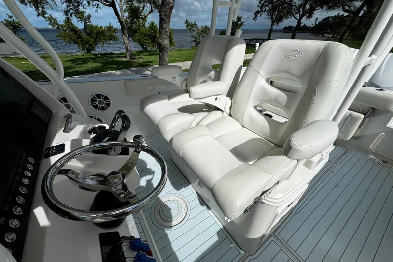 Slide: The Image of Interior of 2015 Sailfish 320 CC boat with white leather seats and steering wheel. - 39
